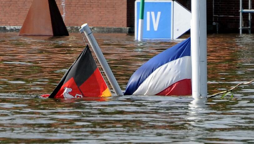 Die Fahnen von Niedersachsen und Schleswig-Holstein hängen am 10.06.2013 vor der Altstadt von Lauenburg (Schleswig-Holstein) im Hochwasser. Nachdem der Wasserstand die 9,30 Meter Grenze überschritten hatte, wurde die Altstadt aufgegeben und alle Helfer und Pumpen abgezogen.