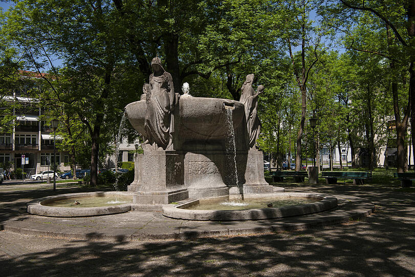 Der Nornenbrunnen heute: Versteckt steht er in der kleinen Grünanlage neben dem IHK-Gebäude am Maximiliansplatz – hinten ist die Ottostraße zu sehen.