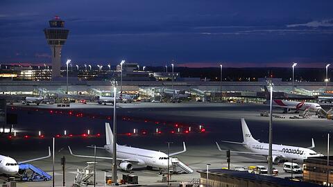 Flugzeuge stehen vor Sonnenaufgang auf dem Flughafen Franz-Josef-Strauß.