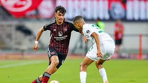Nürnbergs Can Uzun (l) und Fürths Maximilian Dietz kämpfen um den Ball.