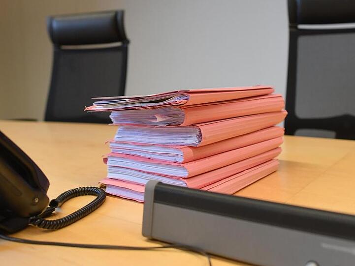 Akten liegen auf dem Tisch des Richters. Foto: Patrick Pleul/zb/dpa/Archivbild