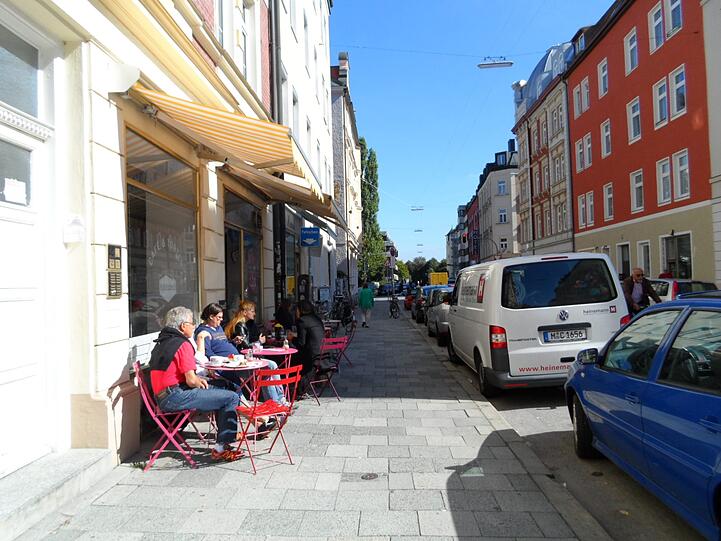In der Sonne vorm Café sitzen sie im T-Shirt. Wenige hundert Meter entfernt vom Trubel in den Bierzelten.