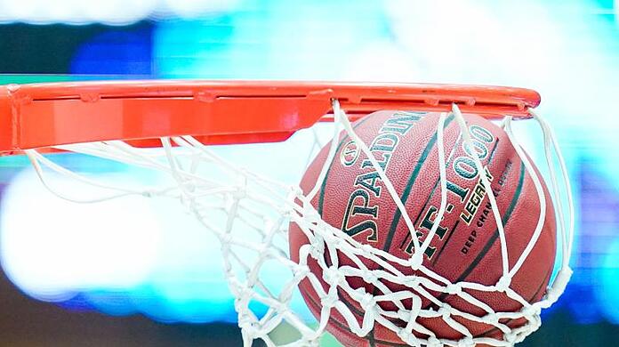 Ein Basketball landet im Korb.