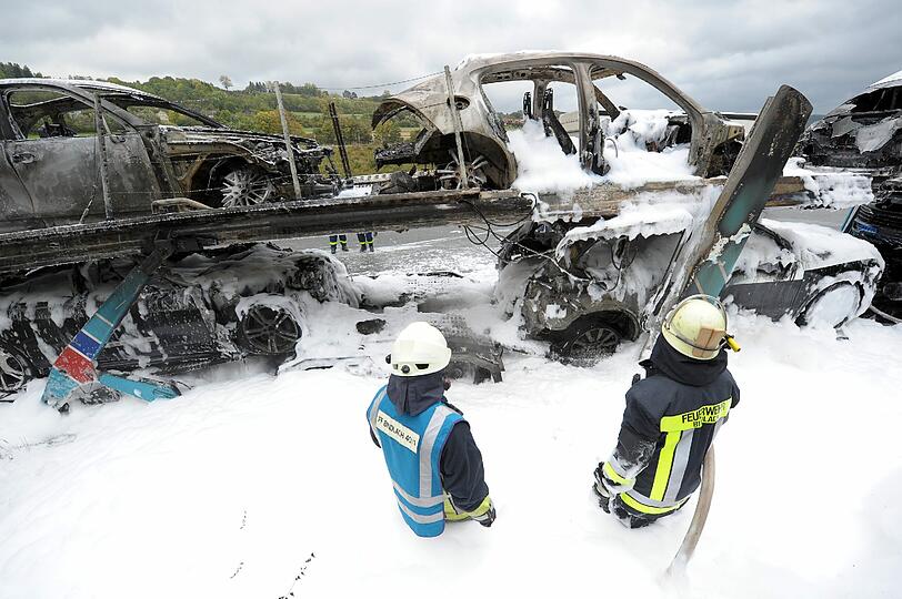 Völlig verbrannt und voller Lösch-Schaum: Auf der A9 bei Bayreuth ist ein Autotransporter in Flammen aufgegangen. Geladen hatte der Lastzug hochwertige Porsche Cayenne und Panamera. Die Bilder.
