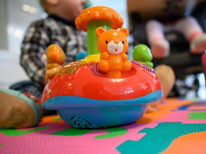 Ein Spielzeug vor zwei Geschwistern. Foto: Sebastian Gollnow/dpa/Illustration