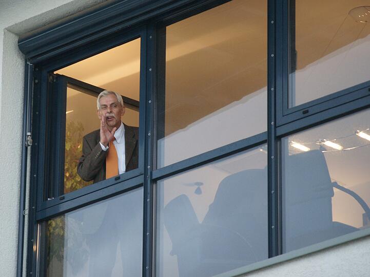 Präsident Dieter Schneider steht vor der Sitzung am Fenster.
