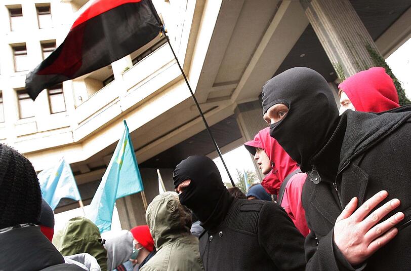Maskierte pro-russische Aktivisten im Regierungsviertel in Simferopol. Bewaffnete Unbekannte sollen Regierungsgebäude gestürmt haben.