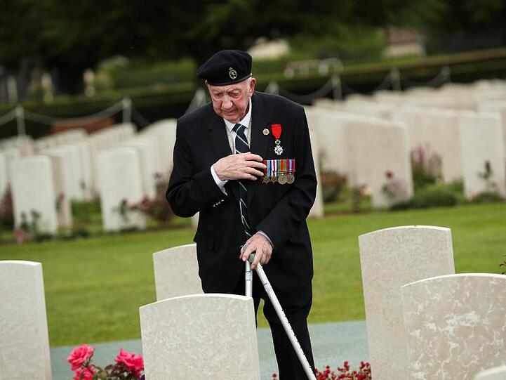 Ein Weltkriegsveteran bekreuzigt sich auf dem Soldatenfriedhof von Bayeux zum 75. Jahrestag des D-Day.
