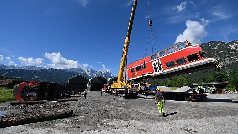 Ein auseinandergeschnittenes Waggonteil wird in einem nahe gelegenen Kieswerk vom Laster gehoben und gelagert. Dort soll es genauer begutachtet werden.