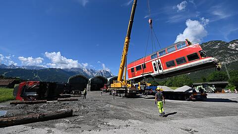 Ein auseinandergeschnittenes Waggonteil wird in einem nahe gelegenen Kieswerk vom Laster gehoben und gelagert. Dort soll es genauer begutachtet werden.