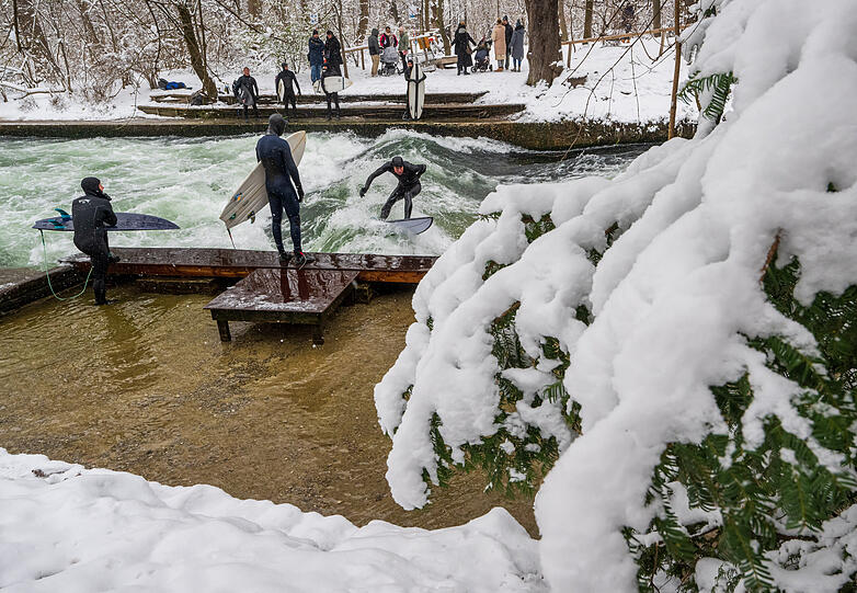 Bei Wind und Wetter auf dem Wasser: Die Surfer an der Eisbachwelle.