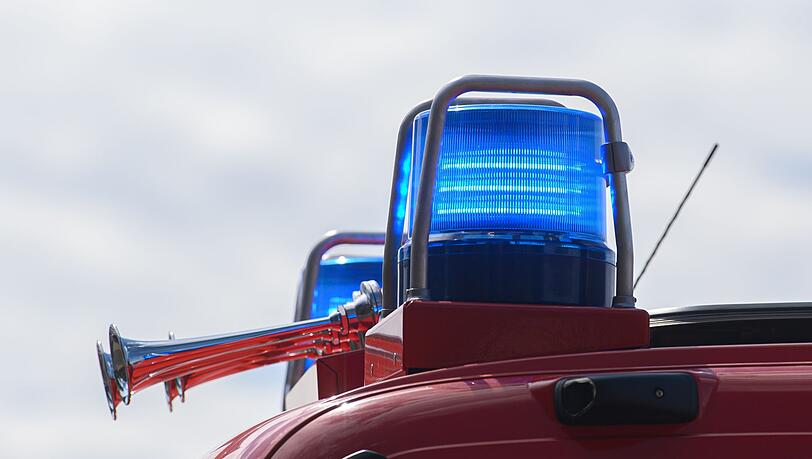 Blaulichter leuchten auf dem Dach eines Einsatzfahrzeugs der Feuerwehr.