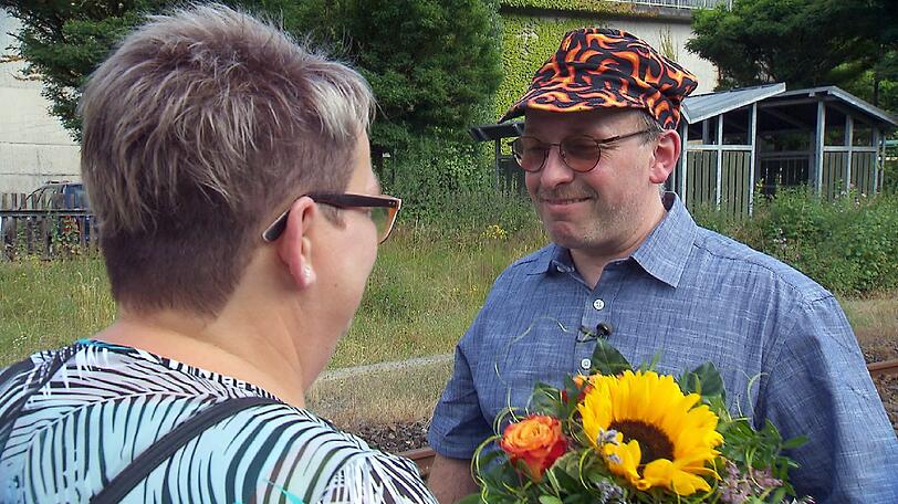 Berthold begrüßt seine Anja mit einem Blumenstrauß