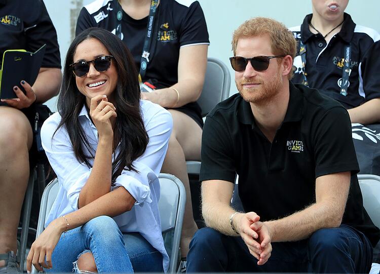 Casual-Chic: Herzogin Meghan verfolgt in lässiger Bluse und destroyed Jeans ein Rollstuhltennis-Spiel mit Prinz Harry.