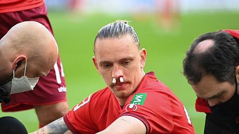 Kölns Marius Wolf muss nach einem Zusammenprall behandelt werden.