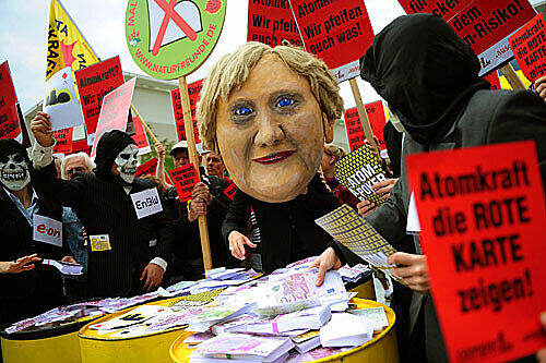 ernkraftgegner inszenieren vor dem Kanzleramt einen &bdquo;Atom-Poker&ldquo; mit einer Merkel-Puppe.