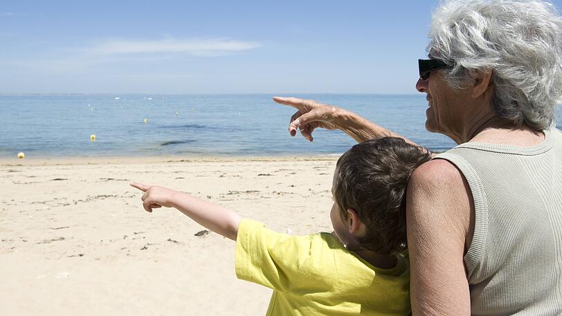 Eine Großmutter genießt die Zeit mit ihrem Enkel am Strand.