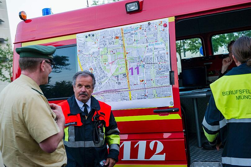 Einsatzkräfte der Feuerwehr besprechen sich im Norden von München. Zuvor wurde auf einer Baustelle eine 250kg Bombe gefunden. Diese soll, obwohl ein Teil des Sprengstoffes ausgetreten ist, entschärft werden.