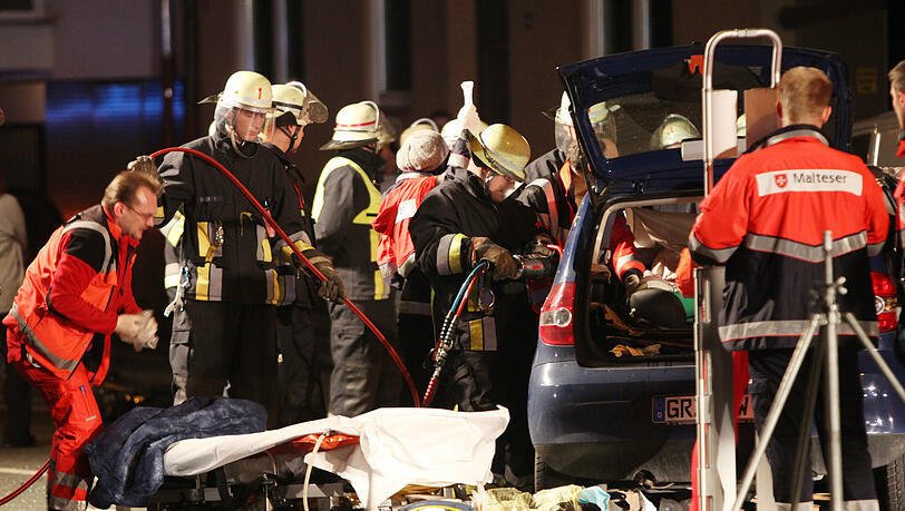 Der Rettungsdienstler (links im Foto) wartet vor der Trage, dass die Feuerwehrmänner die Frau aus dem Auto befreien. Der Rettungsdienstler (links im Foto) wartet vor der Trage, dass die Feuerwehrmänner die Frau aus dem Auto befreien.