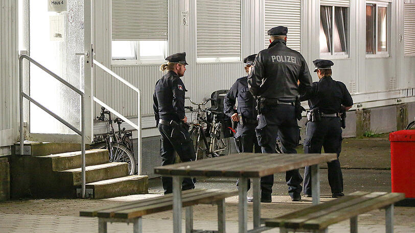 Polizisten durchsuchen bei einer Razzia die Flüchtlingsunterkunft, in der der Messerangreifer gelebt hat. Hier fahnden die Beamten wohl auch die IS-Fahne.