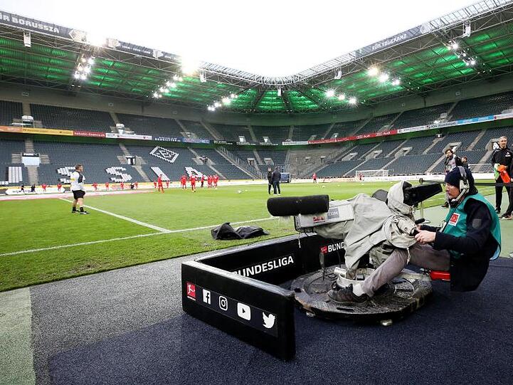 Ein Kameramann filmt das Aufwärmen der Mannschaften im zuschauerfreien Stadion Borussia Park.