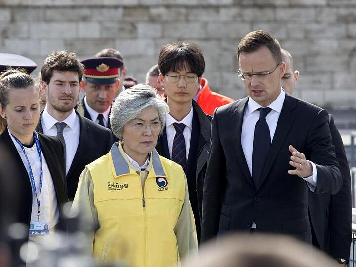 Südkoreas Außenministerin Kang Kyung Wha (M) und Ungarns Außenminister Peter Szijjarto (r) in der Nähe des Unglücksortes.