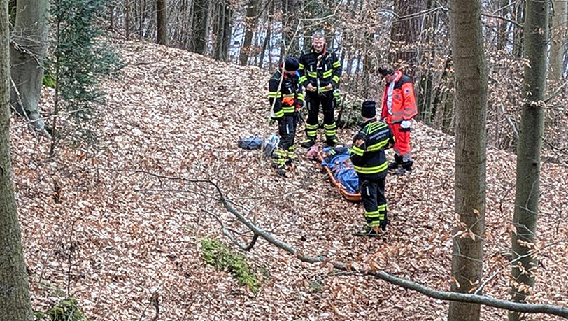 Die Helfer bergen die verketzte Frau an dem steilen Hang im Wald bei Harlaching.