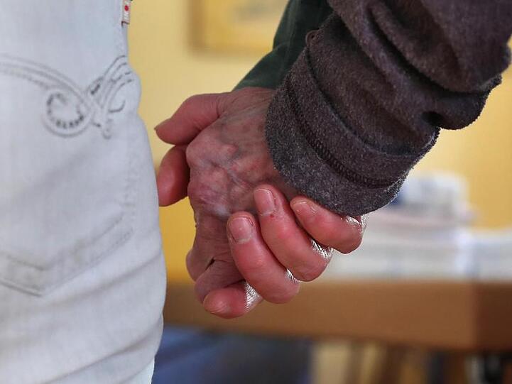 Eine Pflegedienstleiterin führt eine Bewohnerin der Demenz-Wohngemeinschaft an der Hand. Foto: Karl-Josef Hildenbrand/dpa/Archivbild