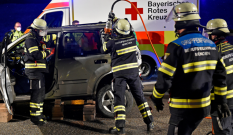 Die Berufsfeuerwehr München befreit den Fahrer eines Kleinwagens aus seinem Auto nach einem Auffahrunfall.