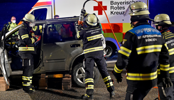 Die Berufsfeuerwehr München befreit den Fahrer eines Kleinwagens aus seinem Auto nach einem Auffahrunfall.