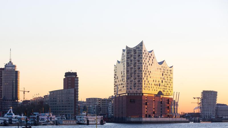 Die Elbphilharmonie leuchtet in der aufgehenden Sonne.