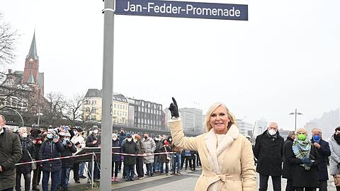 Witwe Marion Fedder unter dem neuen Straßenschild der Jan-Fedder-Promenade.