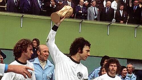 Weltmeister 1974: Paul Breitner (ganz rechts) schaut auf Franz Beckenbauer mit dem Pokal. Weltmeister 1974: Paul Breitner (ganz rechts) schaut auf Franz Beckenbauer mit dem Pokal.