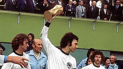 Weltmeister  1974: Paul Breitner (ganz rechts) schaut auf Franz Beckenbauer mit dem Pokal.