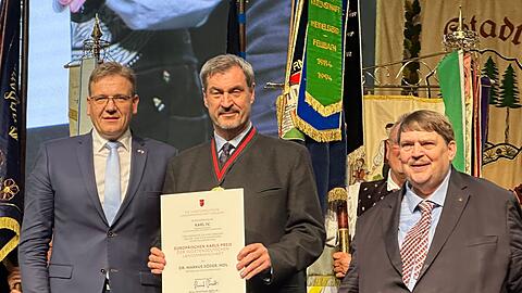 Ministerpräsident Markus Söder (CSU, M) freut sich über den Europäischen Karls-Preis der Sudetendeutschen Landsmannschaft. Überreicht haben die Auszeichnung Steffen Hörtler (l), Landesobmann der Sudetendeutschen Landsmannschaft, und Sprecher und Laudator Bernd Posselt.
