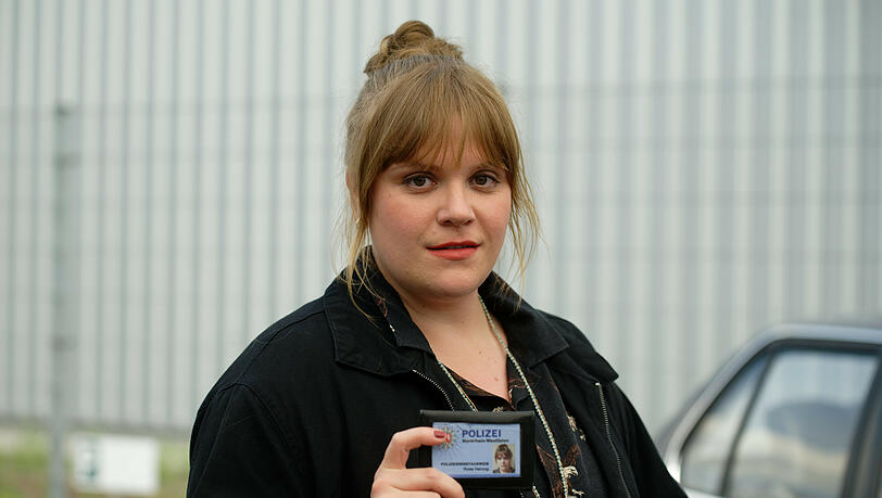 Die Schauspielerin Stefanie Reinsperger als Hauptkommissarin Rosa Herzog steht bei einem Fototermin bei Dreharbeiten zum Dortmunder "Tatort - Heile Welt" auf einem Parkplatz und zeigt ihren Dienstausweis. Die Schauspielerin Stefanie Reinsperger als Hauptkommissarin Rosa Herzog steht bei einem Fototermin bei Dreharbeiten zum Dortmunder "Tatort - Heile Welt" auf einem Parkplatz und zeigt ihren Dienstausweis.