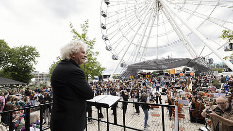 Simon Rattle beim Flashmob des BR-Symphonieorchesters im Werksviertel vor dem Riesenrad.
