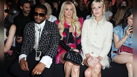 In der Front Row bei Chanel: Paris (Mitte) und Nicky Hilton. Neben ihnen sitzt Pop-Star Usher.