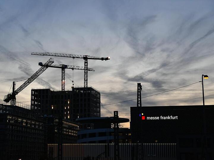 Blick auf Baukräne am Gelände der Frankfurter Messe am Abend.
