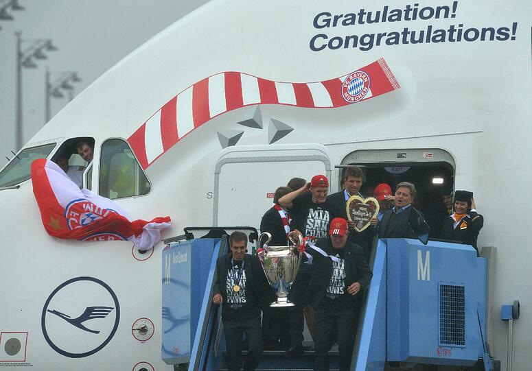 Herzlich Willkommen dahoam! Die Bayern-Spieler kommen mit dem Pott zurück nach München. Die Bilder.