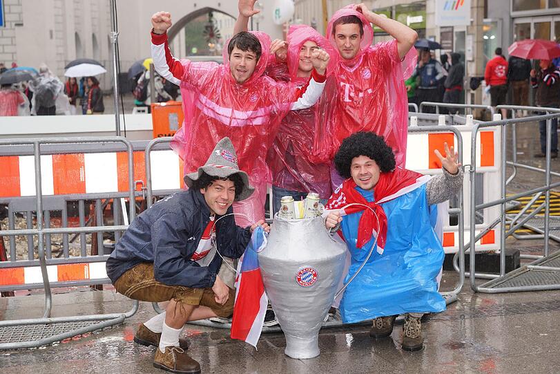 Das lange Warten auf die Pokalhelden. Es regnet und regnet und dennoch warten schon tausende Bayern-Fans auf das Eintreffen der Bayern-Stars. Die Bilder vom Marienplatz
