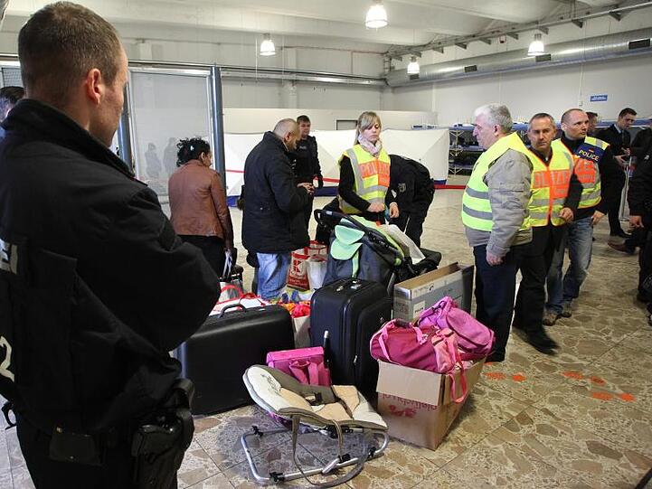 Polizisten begleiten abgelehnte Asylbewerber zu einem Terminal.