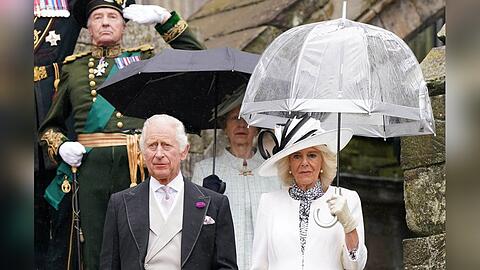 König Charles III. und Königin Camilla während ihrer regnerischen Gartenparty in Edinburgh.
