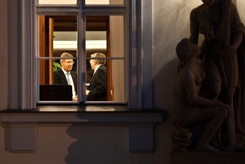 Bundespraesident Christian Wulff (l.) gibt am Mittwoch (04.01.12) in Berlin kurz bevor er seinen Amtssitz im Schloss Bellevue verlaesst, um zur Aufzeichnung des Interviews in ein Fernsehstudio zu fahren, Peter Hintze, Staatssekretaer im Bundeswirtschaftsministerium, die Hand.
