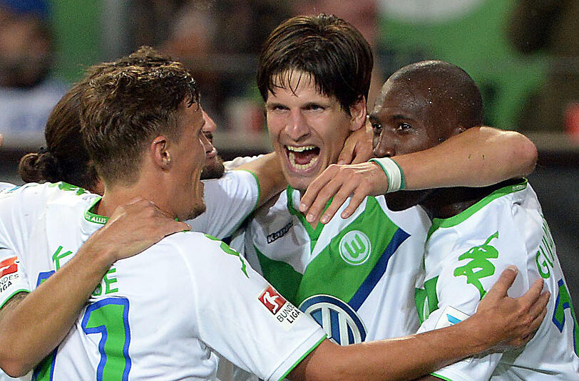 Wolfsburgs Timm Klose (M) bejubelt seinen Treffer zum 3:0 gegen FC Schalke 04 mit Max Kruse (l) und Josuha Guilavogui.