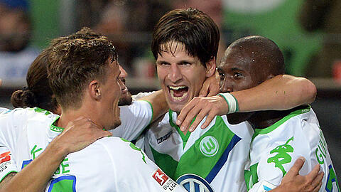Wolfsburgs Timm Klose (M) bejubelt seinen Treffer zum 3:0 gegen FC Schalke 04 mit Max Kruse (l) und Josuha Guilavogui.