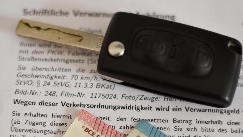 Eine schriftliche Verwarnung wegen zu schnellem Fahren, ein Autoschlüssel und Geldscheine. Foto: picture alliance / Angelika Warmuth/dpa Eine schriftliche Verwarnung wegen zu schnellem Fahren, ein Autoschlüssel und Geldscheine. Foto: picture alliance / Angelika Warmuth/dpa
