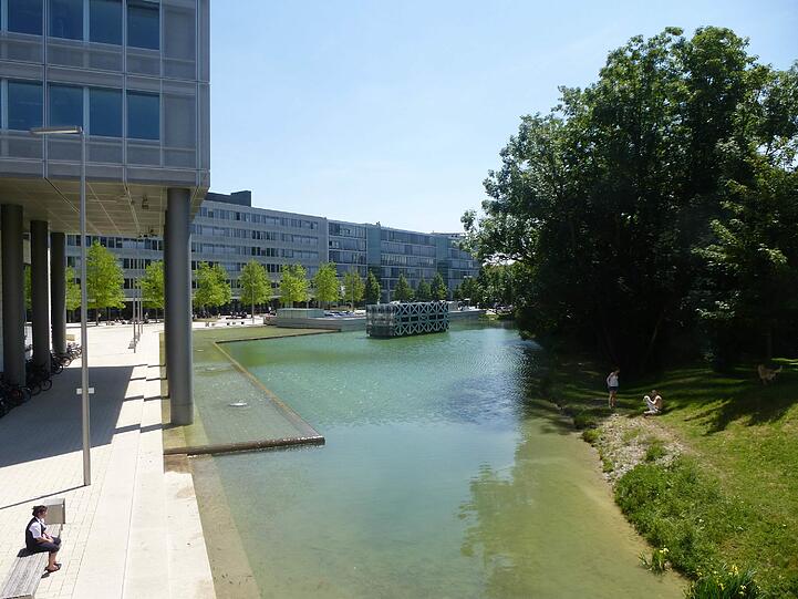 Bänke am Wasser und eine grüne Wiese. Hier kann man schön draußen sitzen.