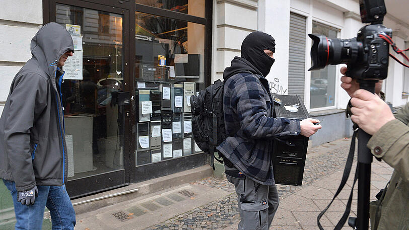 Polizeibeamte tragen am Mittwochvormittag sichergestellte Dinge in Kartons und Papiersäcken aus einem Haus in der Wittstocker Straße in Berlin Moabit