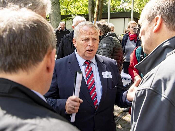 Mecklenburg-Vorpommerns Minister für Landwirtschaft und Umwelt, Till Backhaus, diskutiert vor dem Tagungshotel mit Demonstranten.